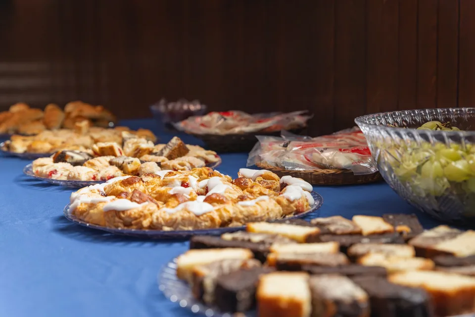 Table sur laquelle est disposé des plats avec de petites bouchées et viennoiseries
