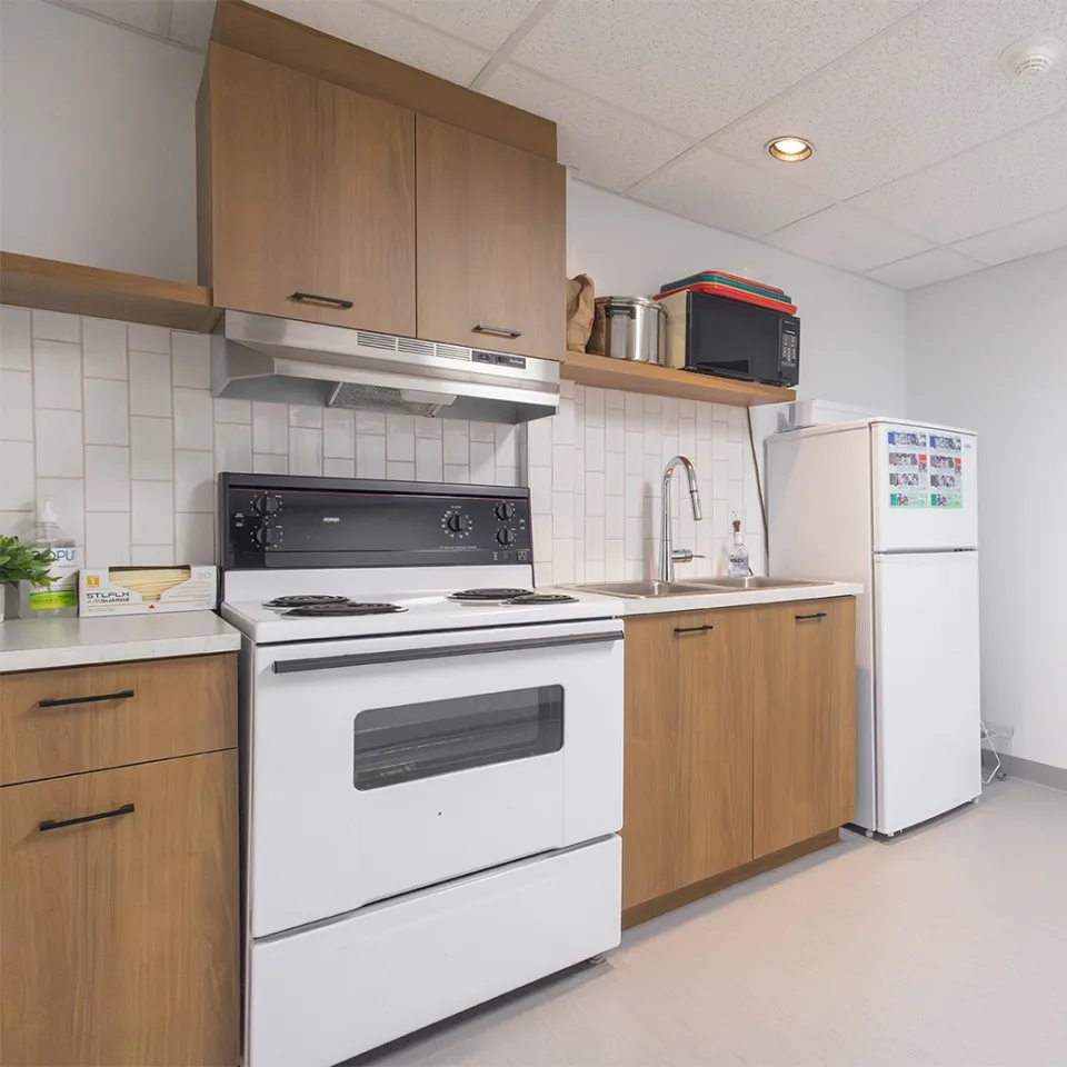 Cuisinette équipée d'un four, d'un réfrigérateur et d'un lavabo.